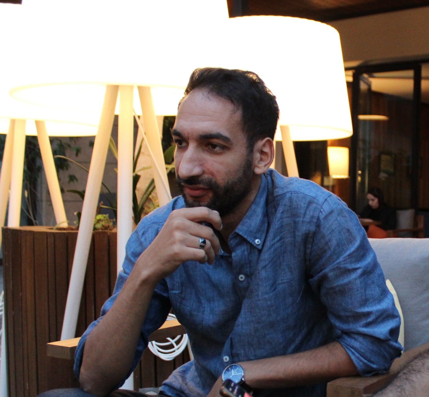 Yassin Elouardi listening, hand to his chin, during a working conversation in Marrakech.
